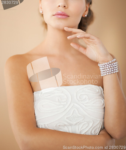 Image of woman with pearl earrings and bracelet