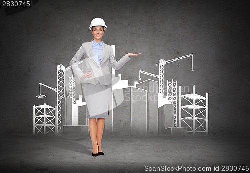 Image of businesswoman in helmet showing construction site