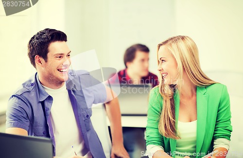 Image of smiling students looking at each other at school