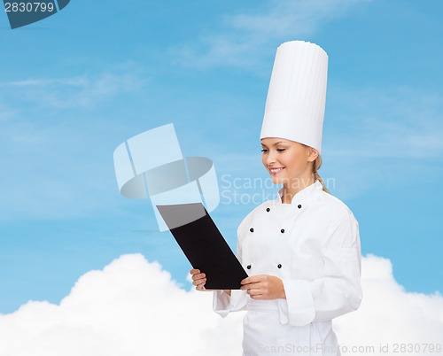 Image of smiling female chef with black blank paper