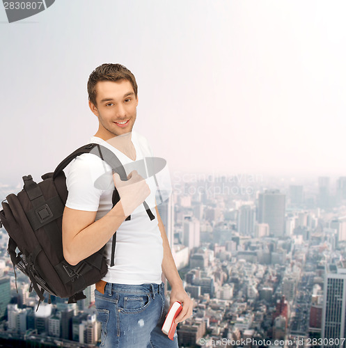 Image of travelling student with backpack and book