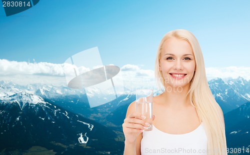 Image of young smiling woman with glass of water
