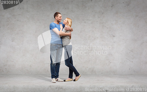 Image of smiling couple hugging and looking at each other