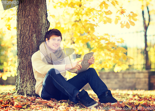 Image of man with tablet pc in autumn park