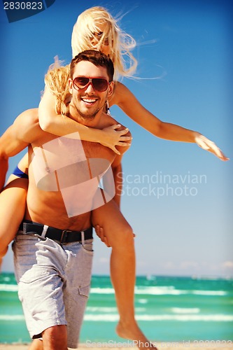 Image of happy couple in sunglasses on the beach