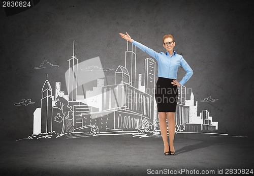 Image of smiling businesswoman in glasses pointing her hand