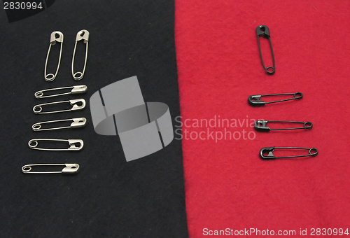 Image of Several fixing pins on black and red felt