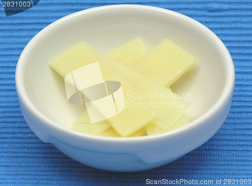 Image of bamboo in a bowl of chinaware on blue background
