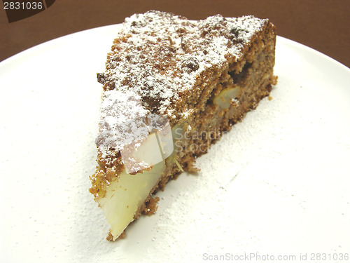 Image of One slice of pear cake on a white plate dusted with powder sugar