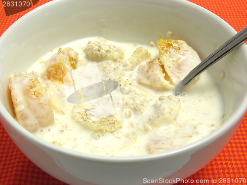 Image of Yoghurt with banana cutted into pieces, tangerine and oat flakes