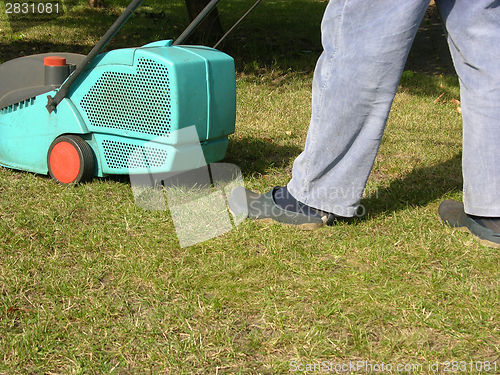 Image of Cutout man with lawn mower doing his work