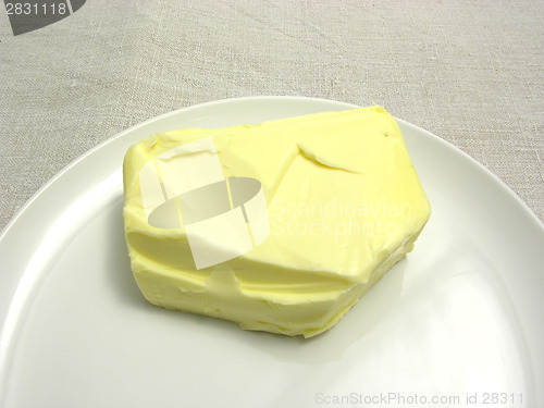 Image of Butter placed on a round plate arranged on a placemat