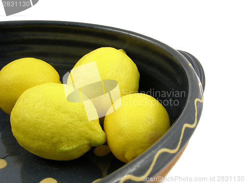 Image of Four yellow citrus fruits in a blue pottery