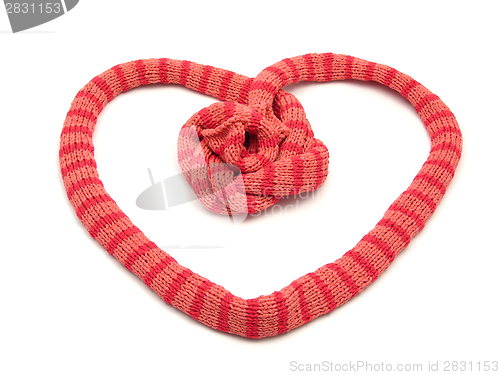 Image of Red striped knitting scarf arranged as heart on white