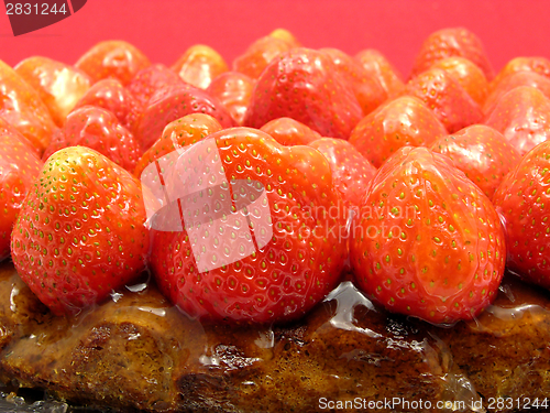 Image of Lateral close-up view of a strawberry cake on red background