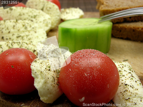 Image of Sliced mozzarella with little tomatoes, a slice of cucumber and wholemeal bread