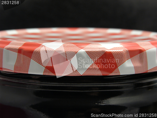 Image of Checked screw lid on a glass and a black background