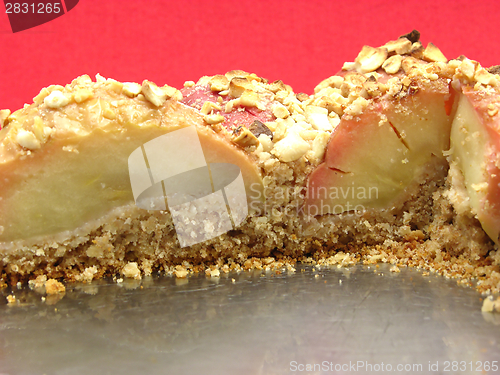 Image of Cutted  wholemeal apple cake  on a cake tray on red background
