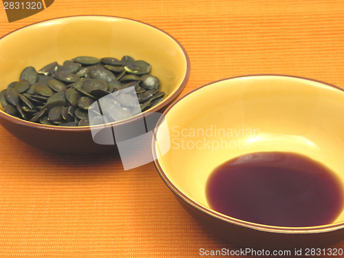 Image of Two bowls of ceramic with pumpkin seeds and pumpkin seed oil