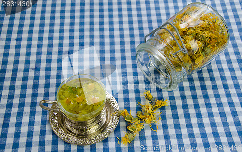 Image of healing marigold tea and jar dried flower on table 