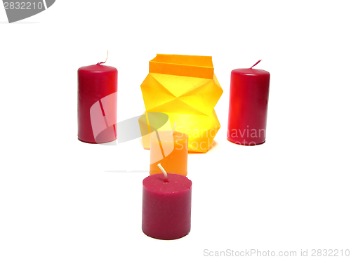 Image of Burning candle in a coloured paper box and other candlesende Kerze in Faltlampe arrangiert mit vier weiteren Kerzen