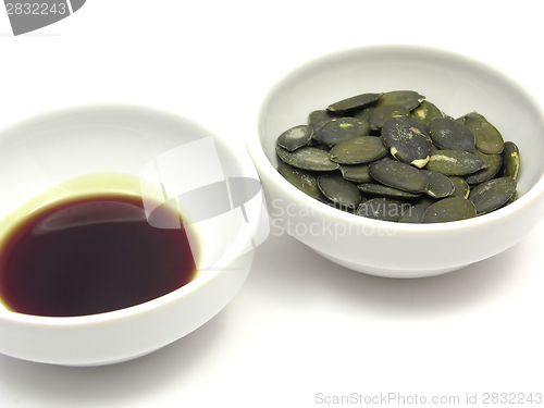 Image of Two bowls of chinaware with pumpkin seeds and pumpkin seed oil