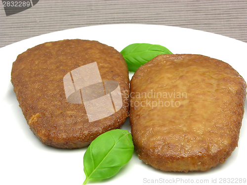 Image of Two breaded bean curd cutlets on a white plate