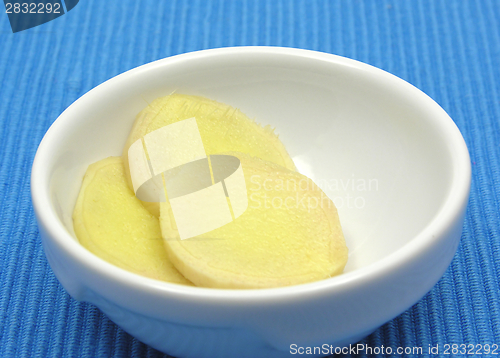 Image of Ginger in a bowl of chinaware on blue background