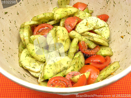 Image of Cucumbers and tomatoes with salat dressing in a bowl of ceramics