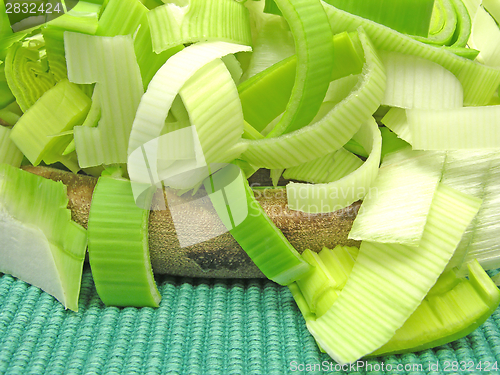 Image of SLiced green leek on a wooden plate