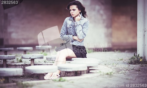 Image of Girl on bench in denim jacket
