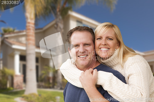 Image of Happy Couple Hugging in Front of House