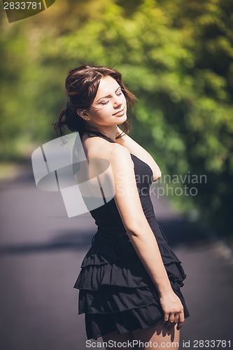 Image of Girl in black dress with her eyes closed