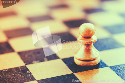 Image of White chess pawn standing on chessboard