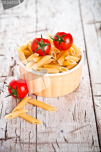 Image of uncooked pasta and cherry tomatoes in a bowl