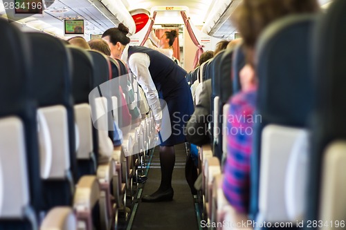 Image of Interior of airplane with passengers on seats.