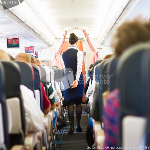 Image of Interior of airplane with passengers on seats.