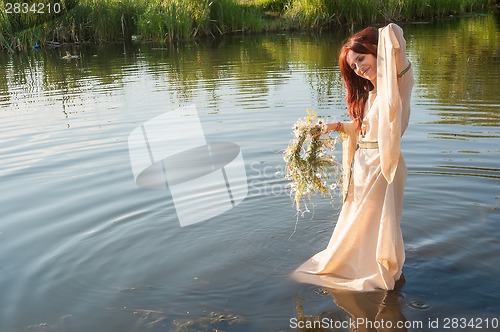 Image of Beautiful red-haired girl relaxes in water