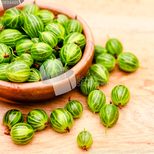 Image of Close-Up Of Gooseberries In Vintage Wooden Bowl On Wooden Table