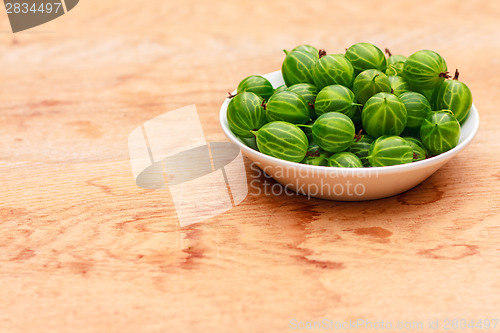 Image of Close-Up Of Gooseberries In Vintage White Dish On Wooden Table