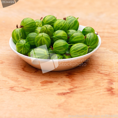 Image of Close-Up Of Gooseberries In Vintage White Dish On Wooden Table