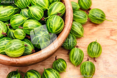 Image of Close-Up Of Gooseberries In Vintage Wooden Bowl On Wooden Table