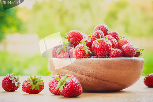 Image of Close-Up Of Strawberries In Vintage Wooden Bowl On Table