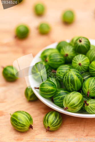 Image of Close-Up Of Gooseberries In Vintage White Dish On Wooden Table
