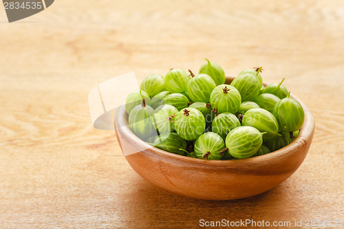 Image of Close-Up Of Gooseberries In Vintage Wooden Bowl On Wooden Table