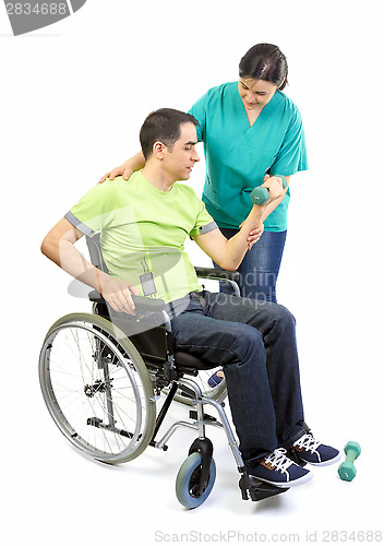 Image of Physical therapist works with patient in lifting hands weights. 