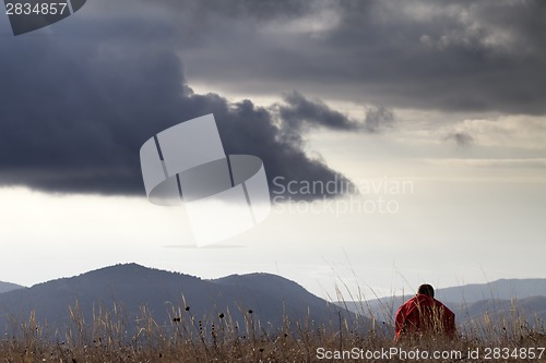 Image of Man resting at mountains in evening