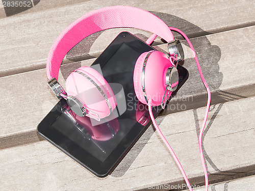 Image of Female pink headphones and tablet pc