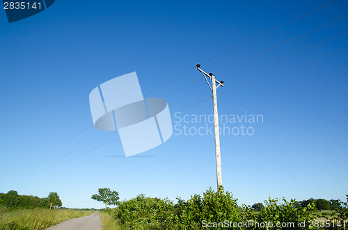 Image of Pole with powerlines at blue sky