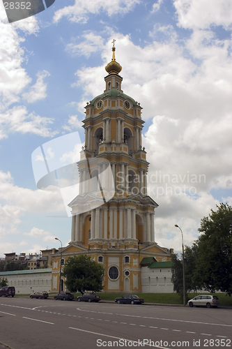 Image of russian bell tower with clock on blue sky background